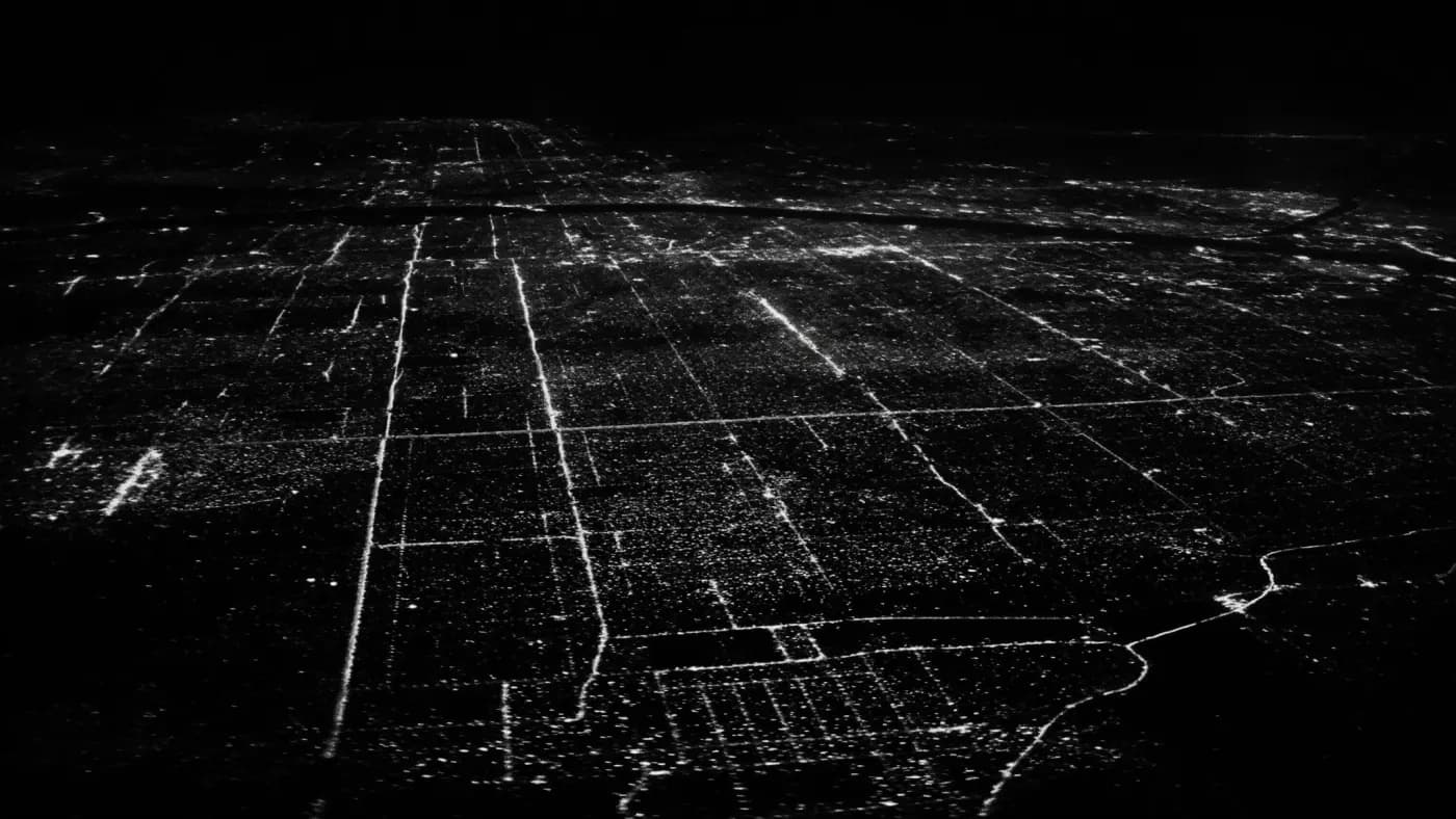 A city grid at night seen from the air, its streets picked out in light.