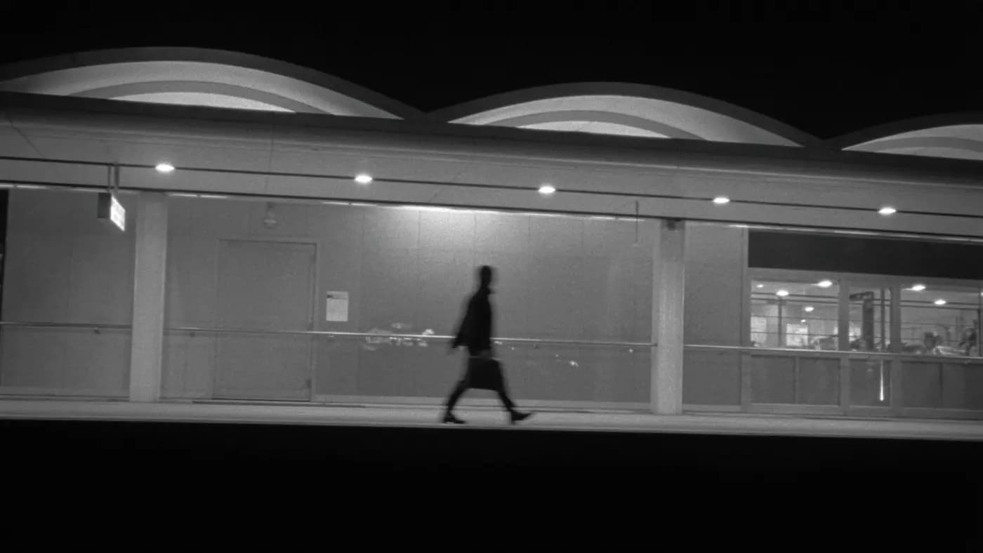 A traveller crossing an empty transit terminal at night.