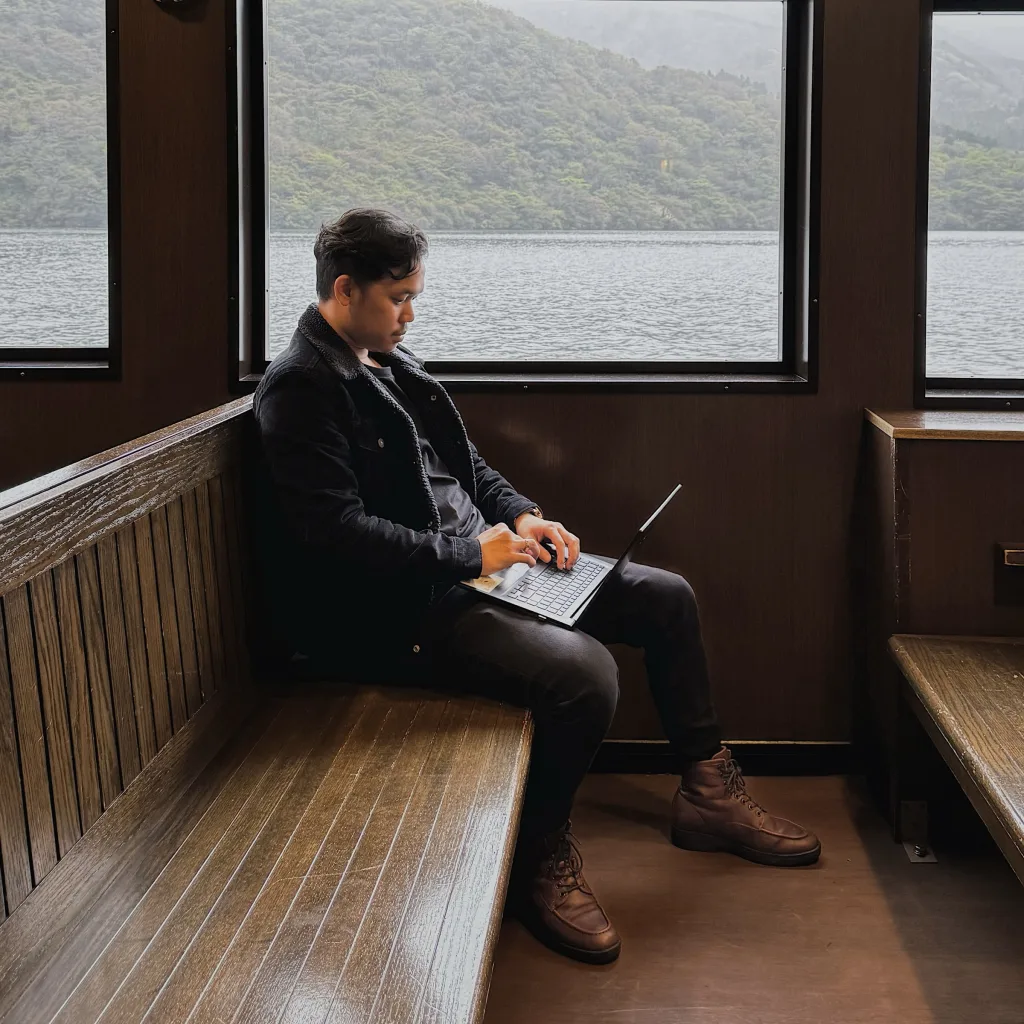 Fabio Jonathan working on a laptop aboard a boat